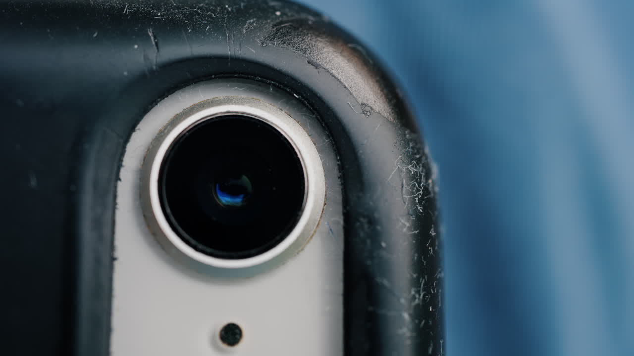 Close up of a smartphone camera lens with scratches on the case