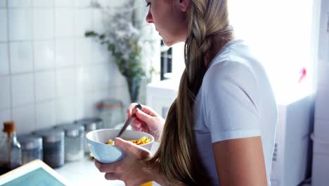 woman using digital tablet while having breakfast