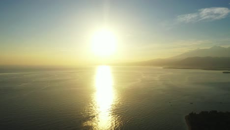 astonishing misty sunrise over the mountains in the tropical ocean, reflective calm water surface