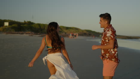 una pareja linda corriendo por la playa.