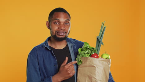 persona afroamericana señalando frutas y verduras de origen ético