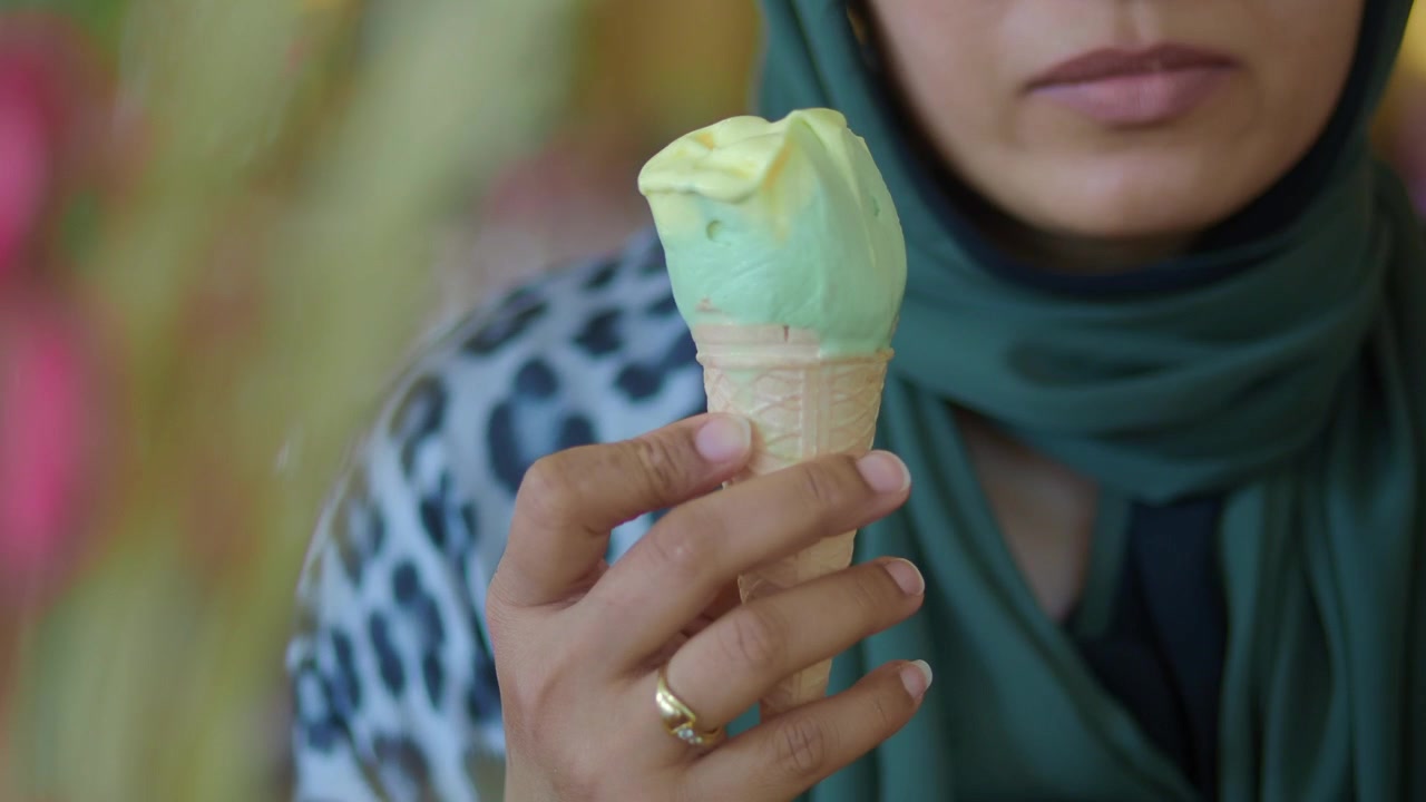 Donna con hijab che mangia un cono gelato