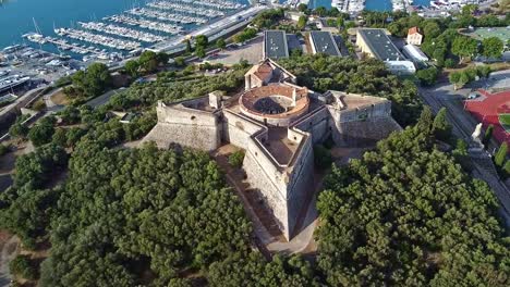 Famous-French-castle-heritage-landmark,-yachts-harbour-moored,-aerial