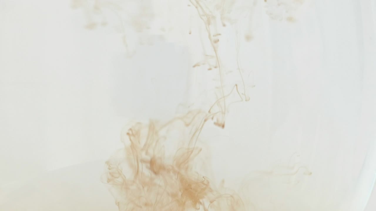 la pintura de aceite negra cae desde arriba mezclándose con el agua, girando sobre un fondo blanco. efectos, fx 4k uhd.