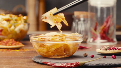 a bowl of comfort food served with chopsticks on a table. the dish contains a delicious recipe with fresh ingredients, perfect for enjoying as a quick meal or dessert