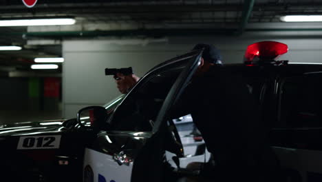 policía saliendo del coche de patrulla