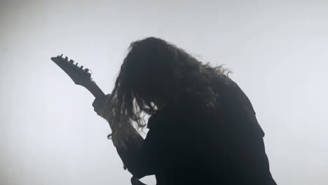 rock musician silhouette playing electric guitar. expressive rock guitarist