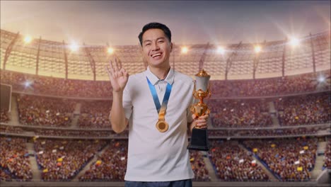 asian man with a gold medal and trophy showing okay gesture and smiling to camera as the first winner at the stadium