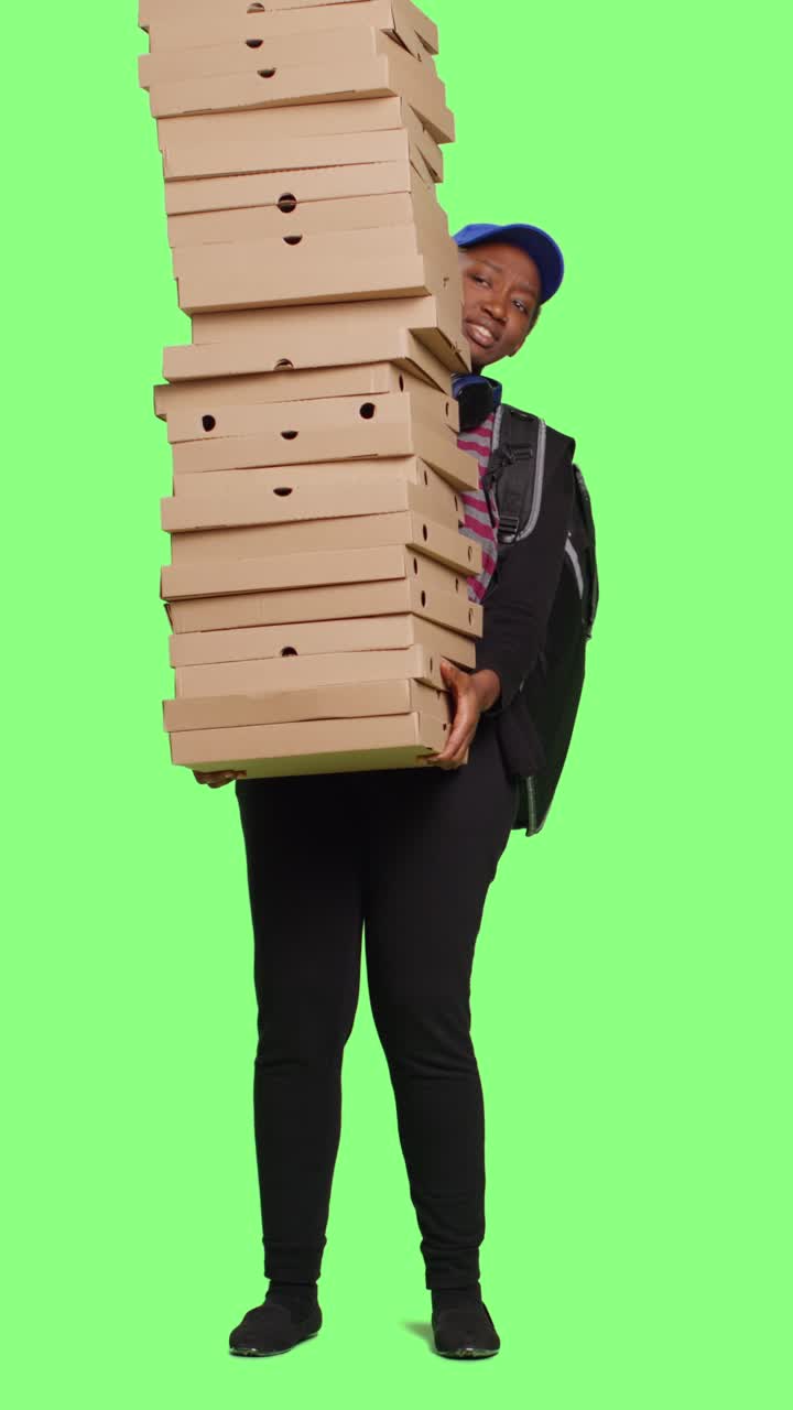 Pekerja restoran pizza mengantarkan tumpukan kotak pizza