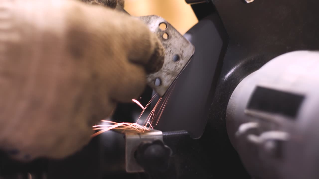 Gloved hands grinding a detail