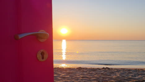 view through an open door to the ocean and sandy beach at sunrise-1