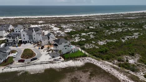 Approaching sideways drone movement to the seaside vacation homes facing the ocean bay on natural green environment, Panama City Beach, Florida, USA