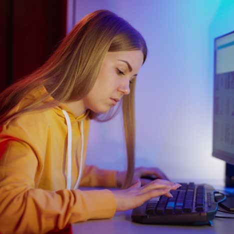 side view of a girl working on a computer. attractive young woman sitting in front of a monitor and looking for some information.