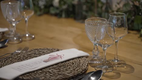 elegant table setting with woven placemat, crystal glassware, and a detailed napkin