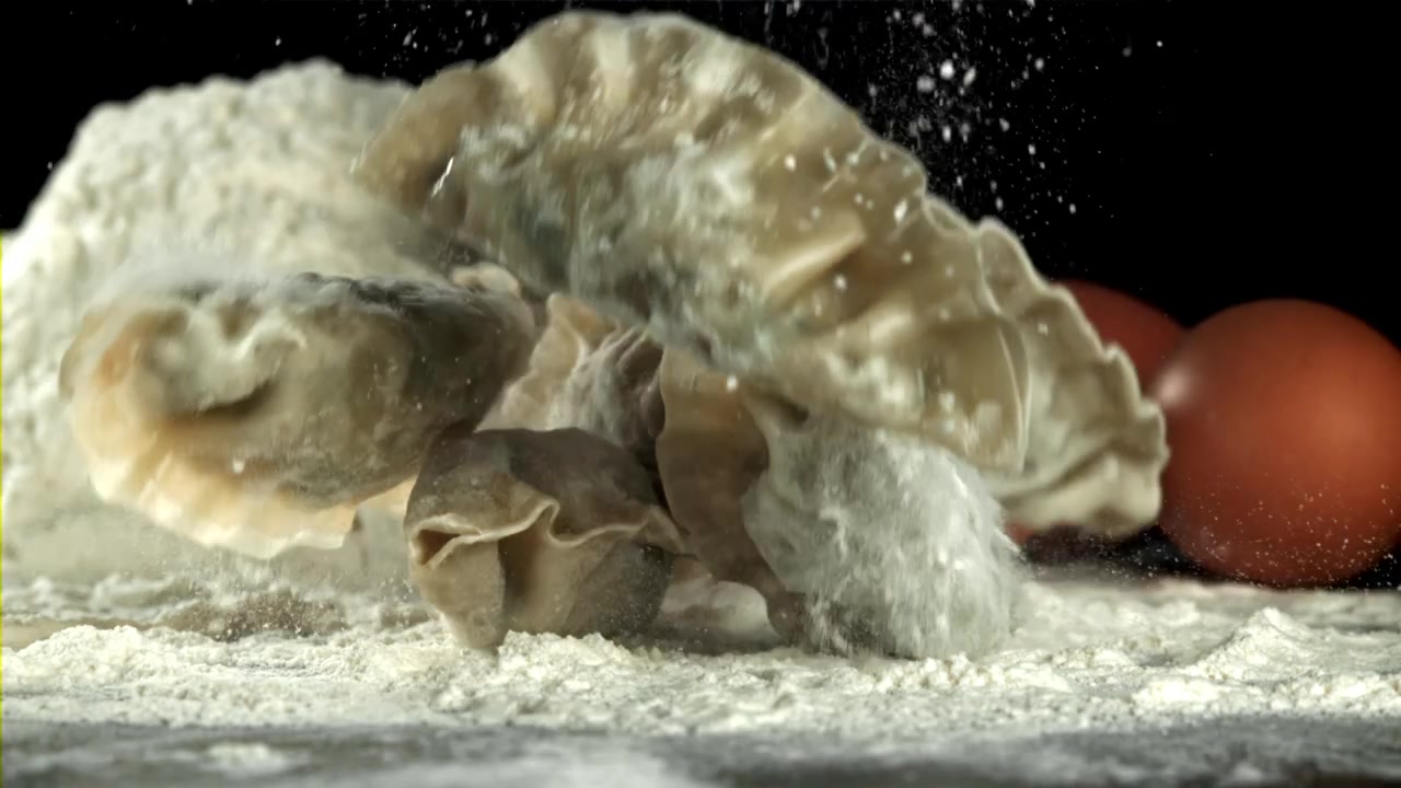 Gnocchi crudi che cadono nella farina con le uova al rallentatore
