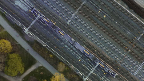 aerial, top down, drone shot of a train on the main railway, between helsinki and pasila railway stations, sunny day, in helsinki, finland