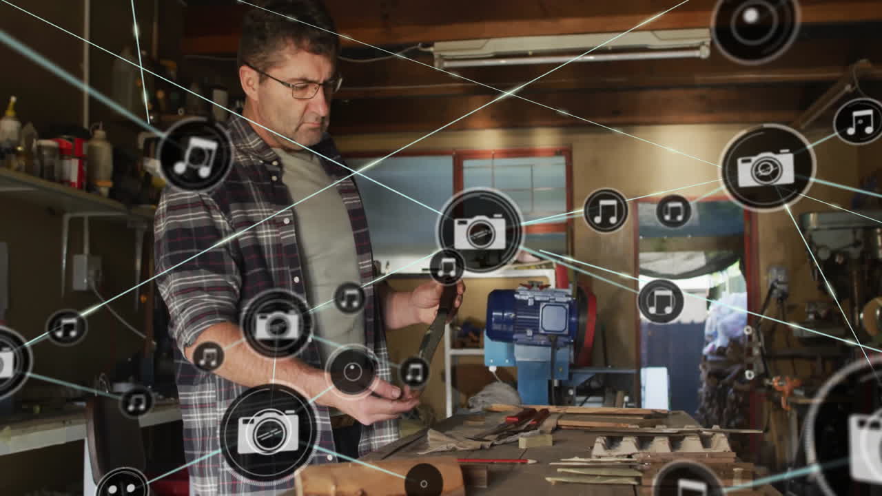 Music and photo icons animation over man working in workshop