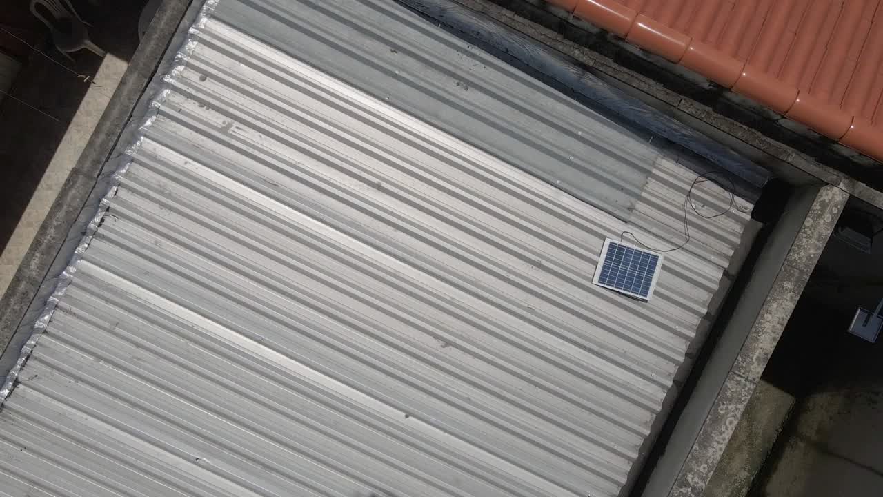 옥상 환경에 태양 전지판을 가진 간단한 겸손한 집의 공중 전망