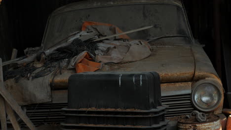 coche clásico viejo y oxidado dejado para degradarse en un garaje