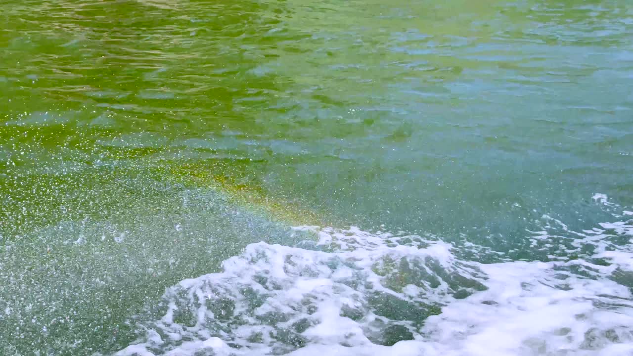 배는 운하에서 스프레이와 무지개를 만니다.