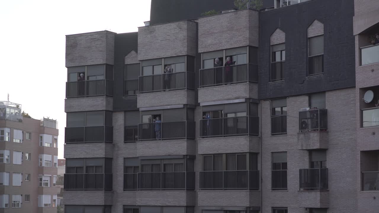 People on balconies of a multi-story building