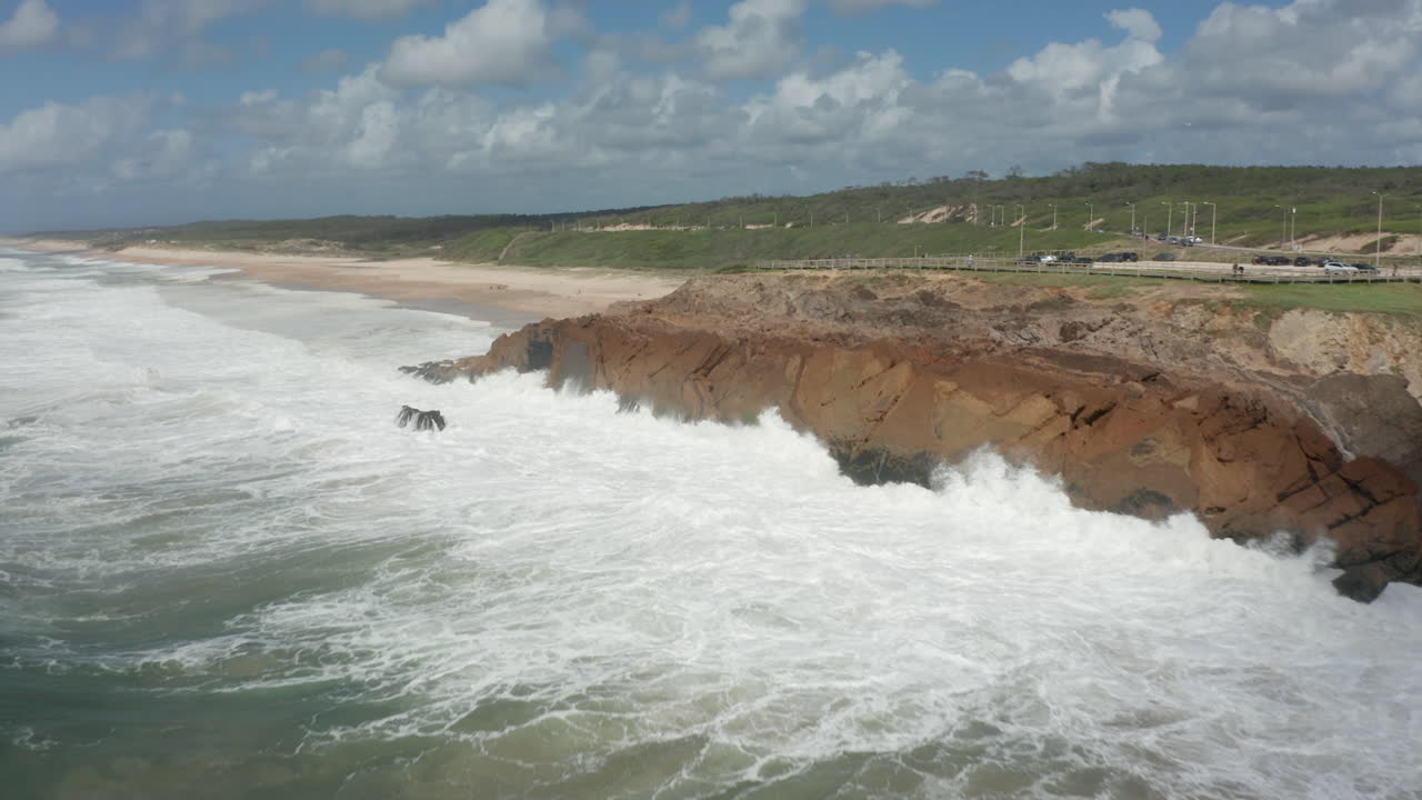 Flying towards rocky cliff with wild waves slamming into them