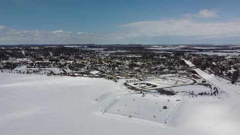 Aerial-Drone-View-Of-Frozen-Lake-And-Marina-On-Sunny-Winter-Day