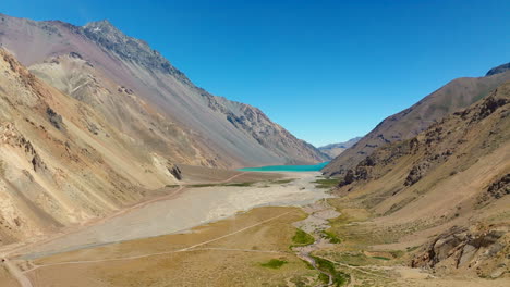 Drone pans over winding road through Cajon del Maipo valley, framed by Chilean mountain scenery