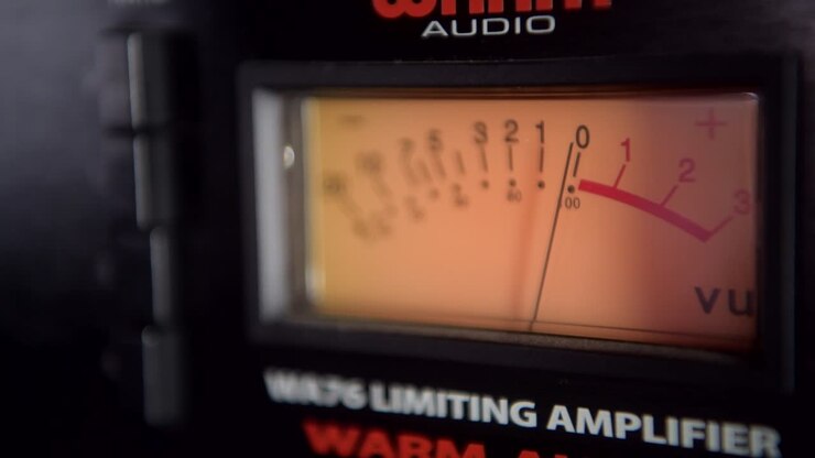 Primo piano di un VU meter su un compressore analogico in uno studio di registrazione