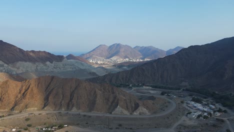 UAE-MOUNTAINS:-Top-View-of-Khorfakkan-village-and-mountains,-a-traditional-northern-town-between-the-hills