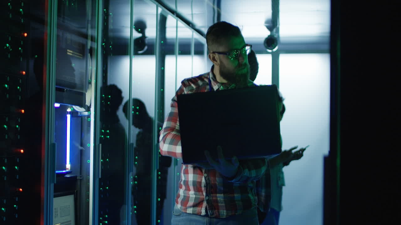 técnico informático trabajando en una sala de servidores por la noche