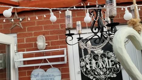 fairy lights, solar chandelier and ornamental decoration hanging inside outdoor garden shelter