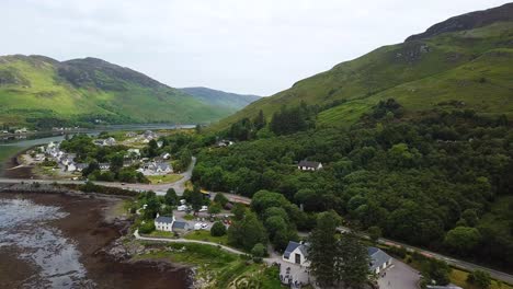 Dornie-Town-Enthüllen-Hinter-Eilean-Donan-Castle,-Schottland,-Luftdrohnenansicht