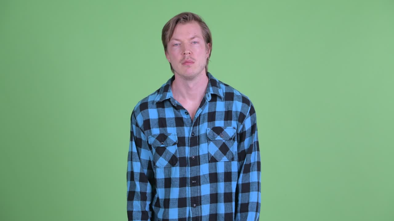 녹색 스튜디오 배경에 찍힌 지루해 보이는 백인 남자의 초상화