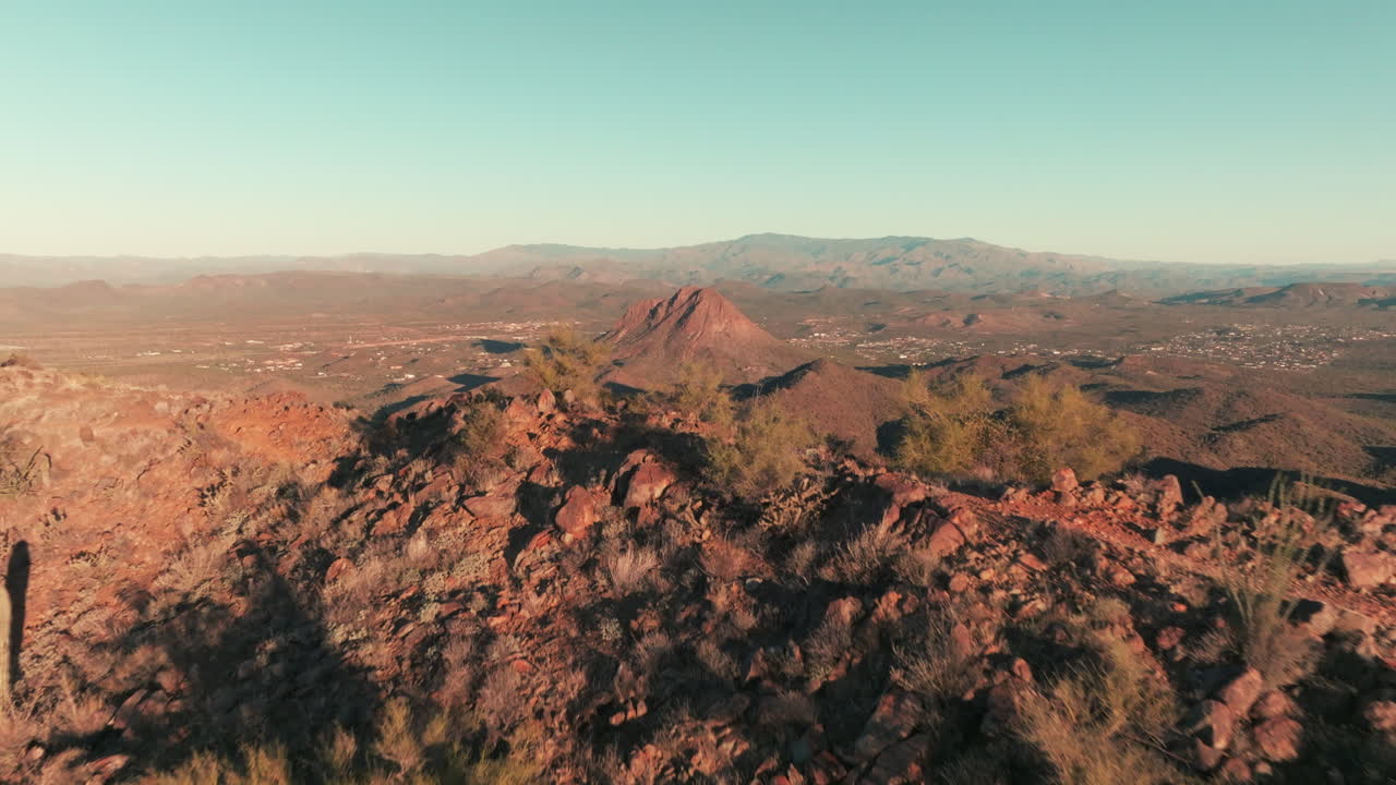 vuelo aéreo sobre el pico de la montaña del desierto hacia himno, arizona en el valle de abajo