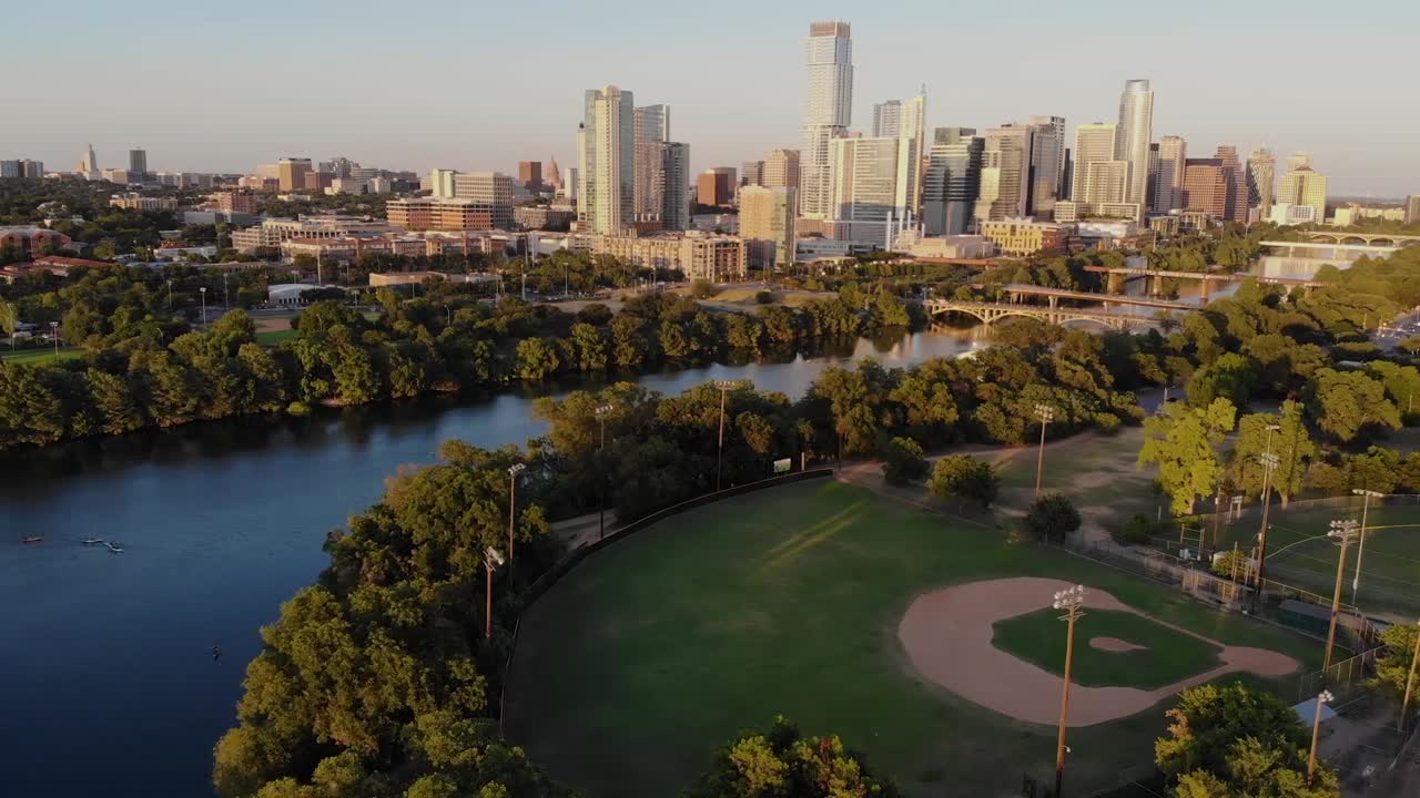 Gravação aérea de drone com panorâmica horizontal de um campo de beisebol para o centro de Austin, Texas.
