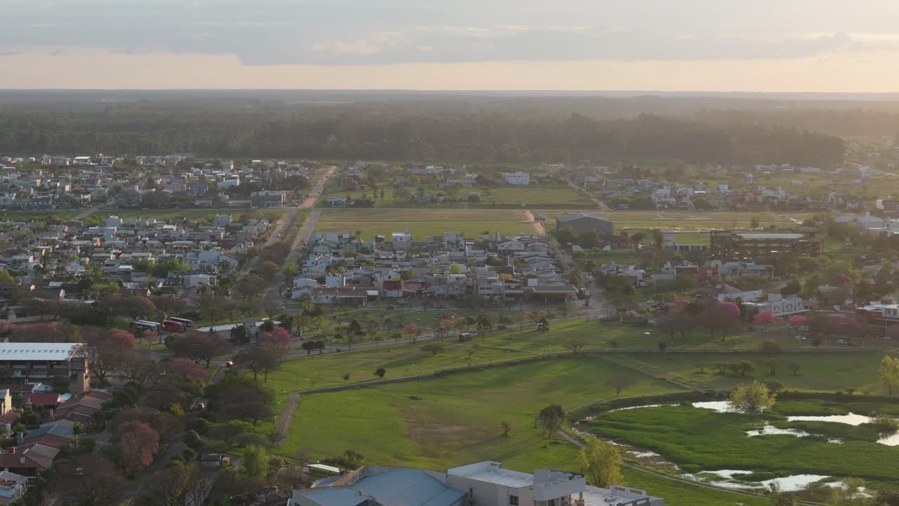 Aerial view of Federacion town at sunset with a mix of buildings, green spaces, and roads, creating a serene and picturesque evening atmosphere, Entre Ríos, Argentina
