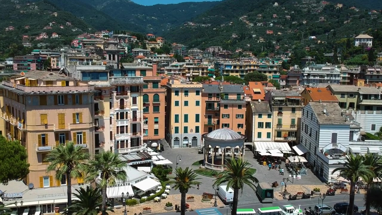 Vista aerea in ascesa davanti al lungomare di Rapallo, giornata di sole in Liguria, Italia