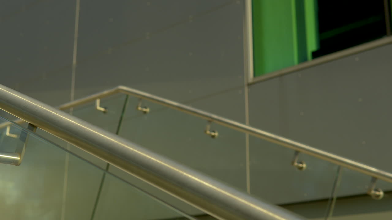 primer plano de una moderna barandilla de acero inoxidable con paneles de vidrio en una escalera