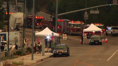 medium shot of waiting fire trucks and news crews near a southern california wild fire