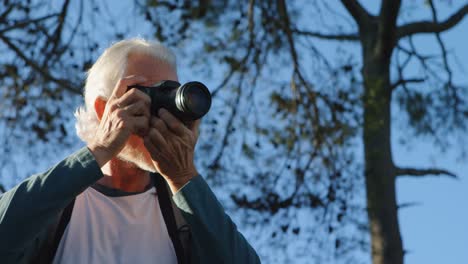 hombre mayor haciendo clic en fotos con cámara digital 4k