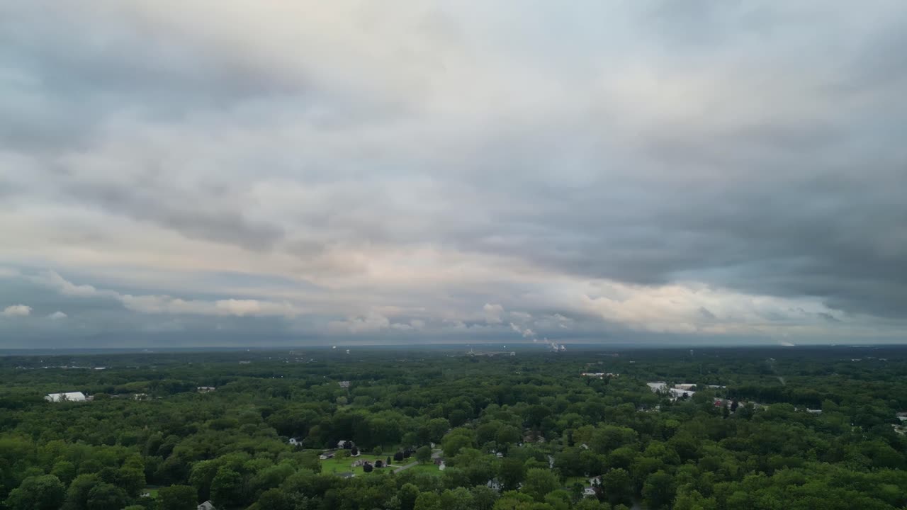 계층화 된 구름으로 가득 찬 기분이 나쁜 하늘은 넓은 초록색 에 부드러운 빛을 습니다.