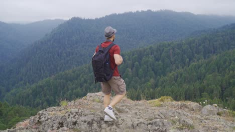 Free-man-standing-on-cliff-at-summit.