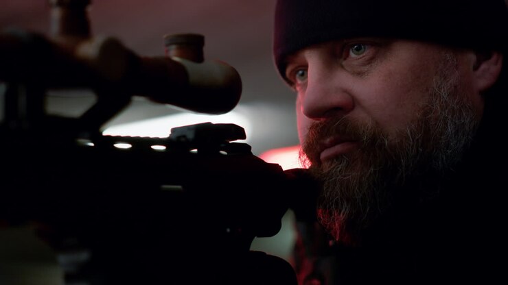 Man preparing to shoot with assault rifle. Hired killer taking aim with weapon