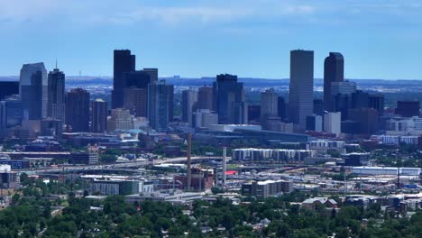 Summer-downtown-Denver-city-skyscrapers-Colorado-aerial-drone-circle-left-traffic-cars-highway-Mile-High-neighborhood-homes-blue-skies-cloudy-6th-avenue-colfax-RTD-line-front-range-foothills-landscape