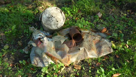 pile of rusty cans and other trash dumped in the grass