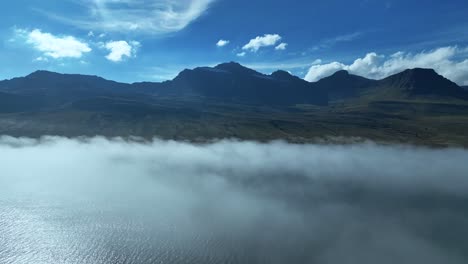 flight above clouds in faskrudsfjordur, east iceland - drone shot