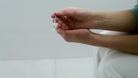 hands holding pregnancy test on bathroom