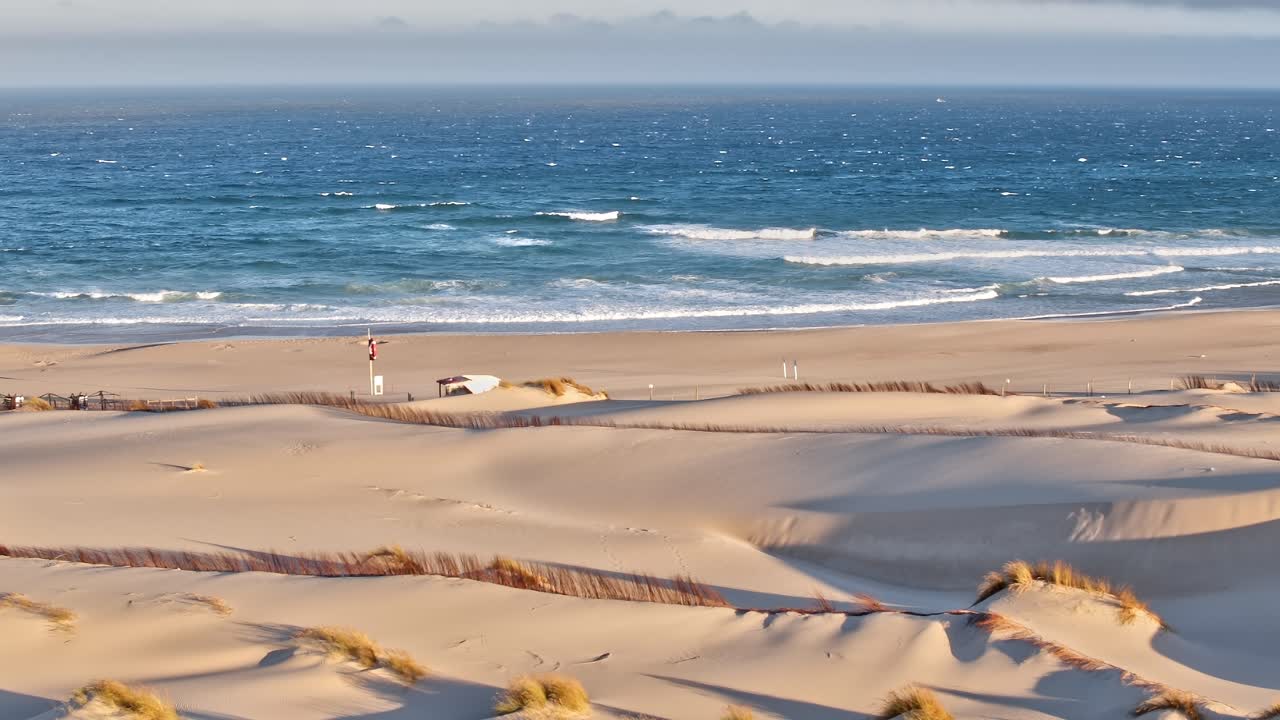 Aerial view of sandy dunes and ocean in Portugal during daytime