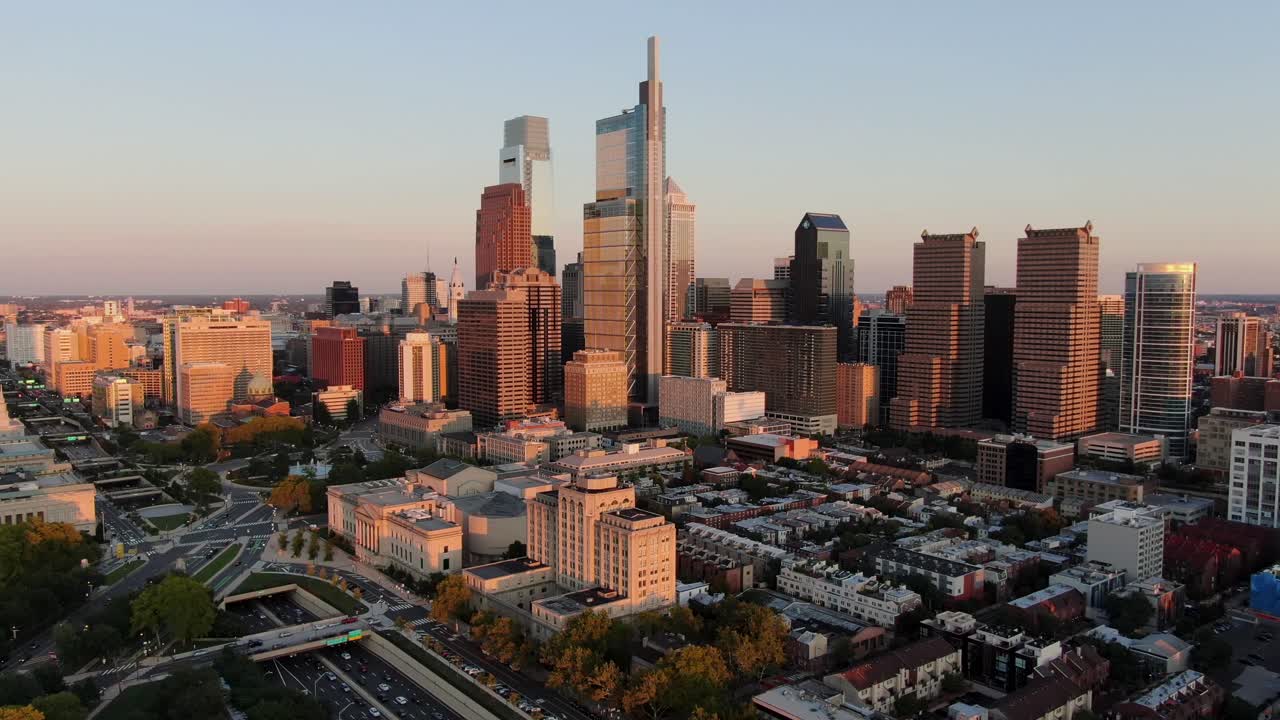 석양의 공중 팬은 필라델피아 스카이라인, 기차역, 슐킬 강, 고속도로 및 공원 도로의 교통량을 보여줍니다.